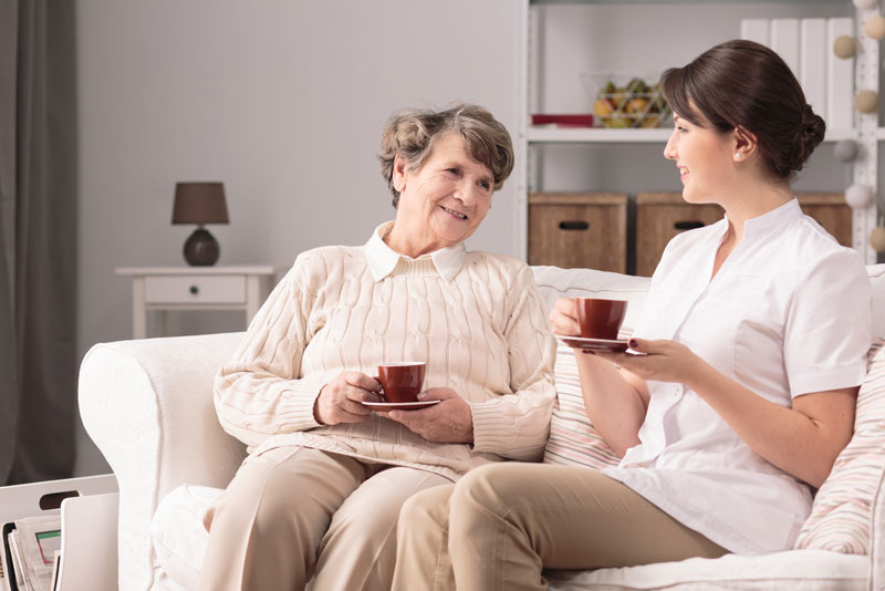 woman drinking tea with caregiver