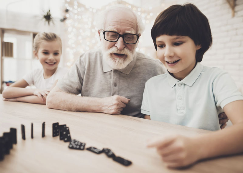 grandfather playing dominoes with grandkids