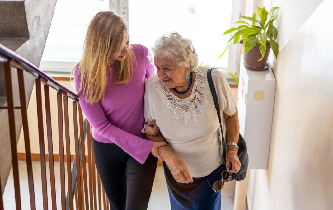 caregiver helping woman up stairs