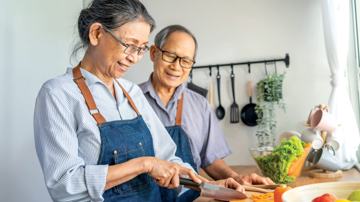 Asian American couple preparing food in kitchen