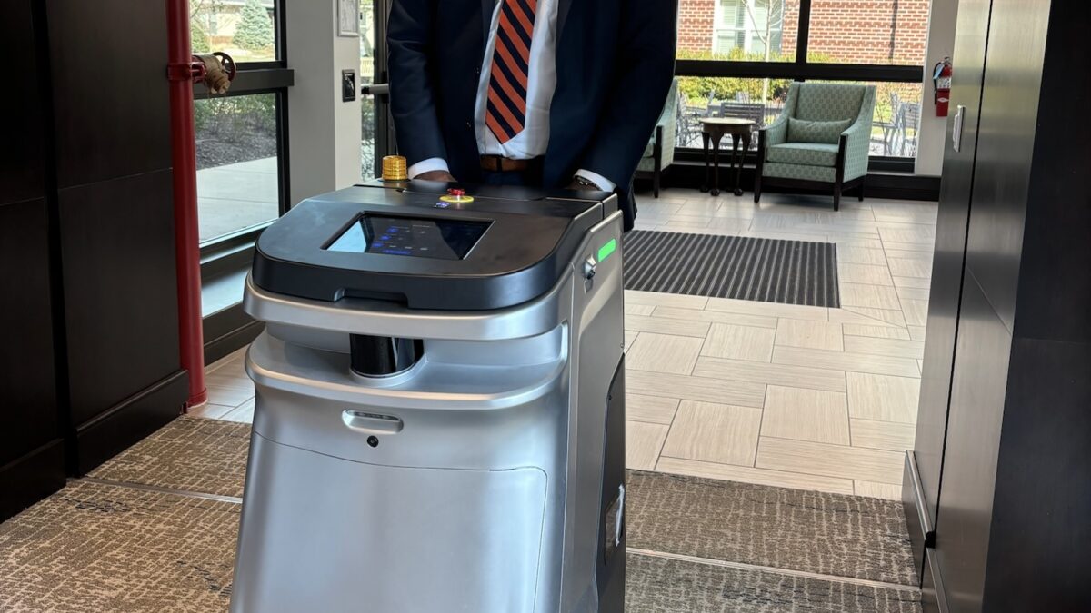 Michael Etheridge with one of Ingleside's cleaning robots.