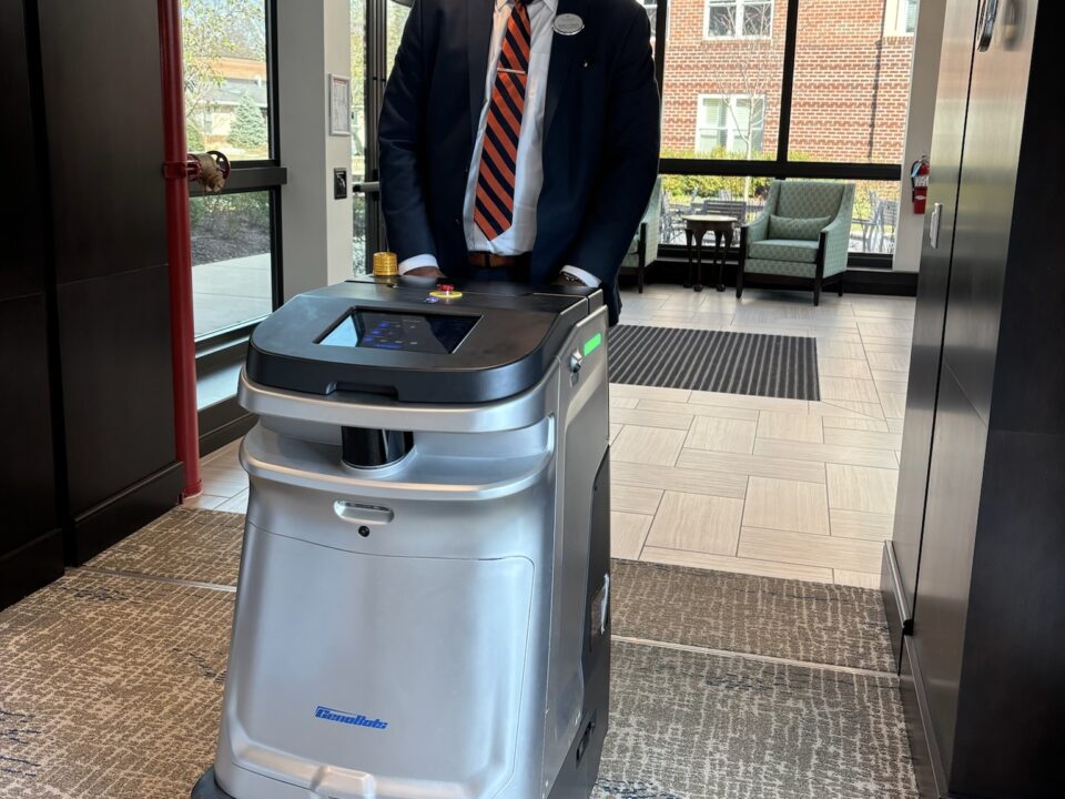 Michael Etheridge with one of Ingleside's cleaning robots.