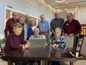 Members of the resident tech team all gathered around a computer together.